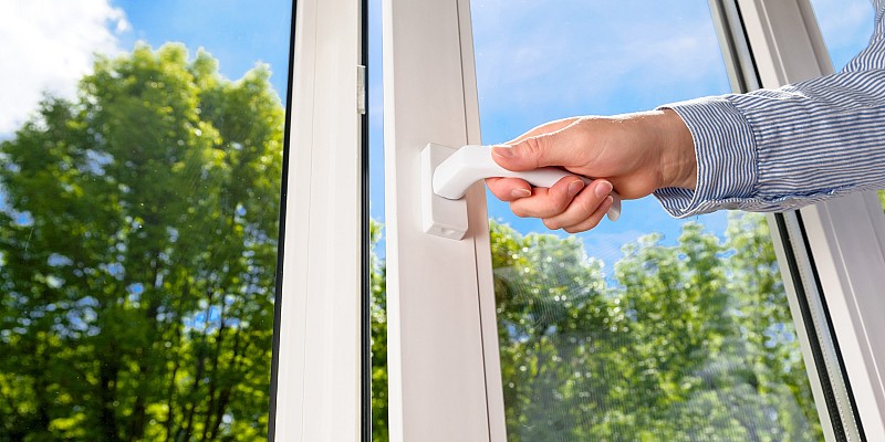 Teilgeöffnete Glastür mit satiniertem Streifendekor in modernem Innenraum.